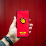 person holding yellow and black iphone case
