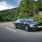 a black car driving down a winding road